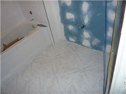Bathroom mid-renovation, finished tub beside a wall at cement-board stage